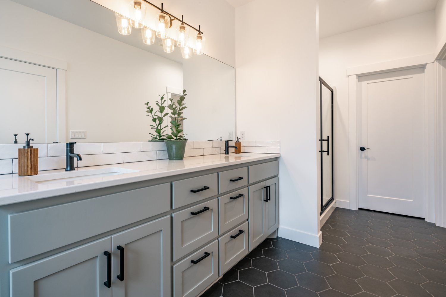 Primary bathroom with double vanity, subway tile, and modern fixtures